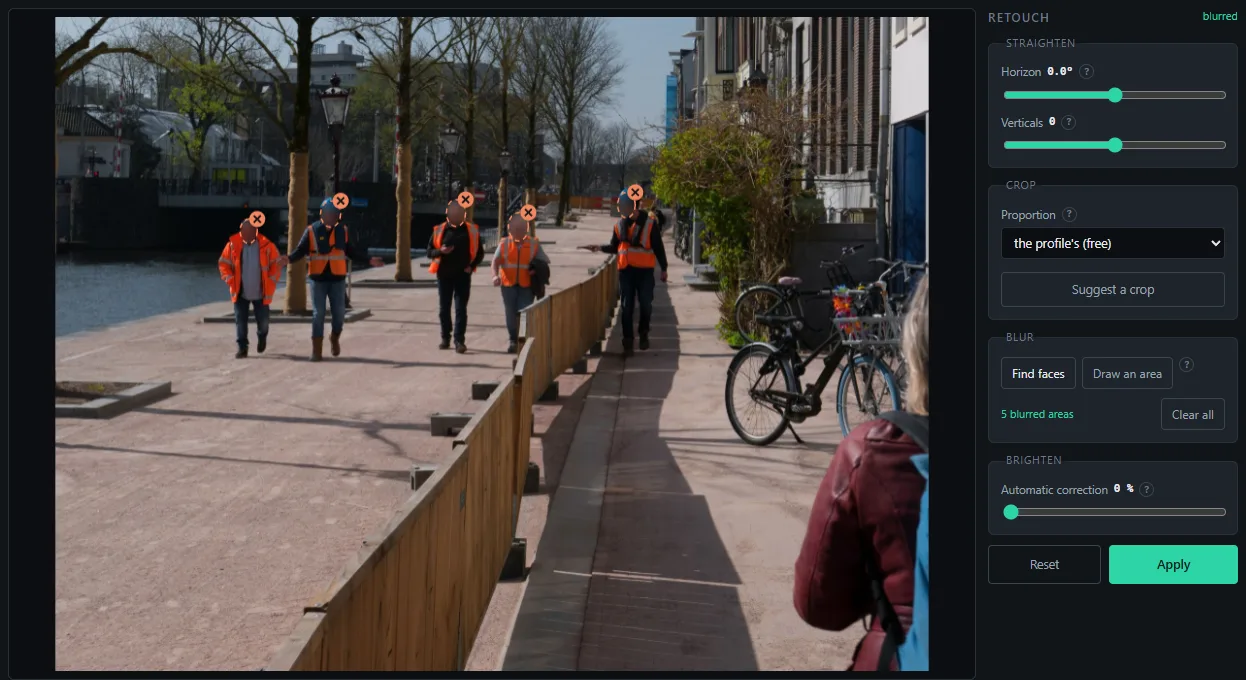 The retouch editor with five faces found and blurred on a site photo.